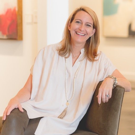 Anne Neilson sitting in a chair within her art studio/gallery